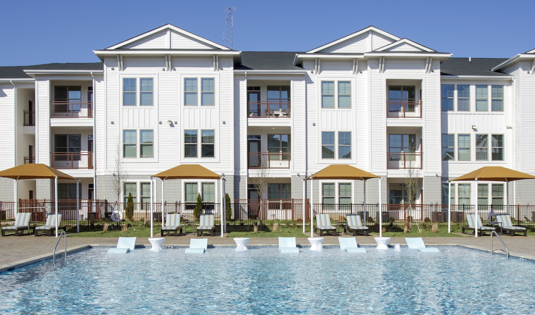 a pool in front of a building with umbrellas